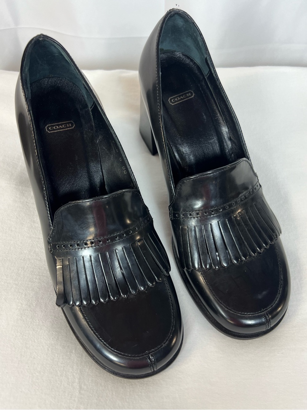 COACH black leather kiltie heeled loafers.